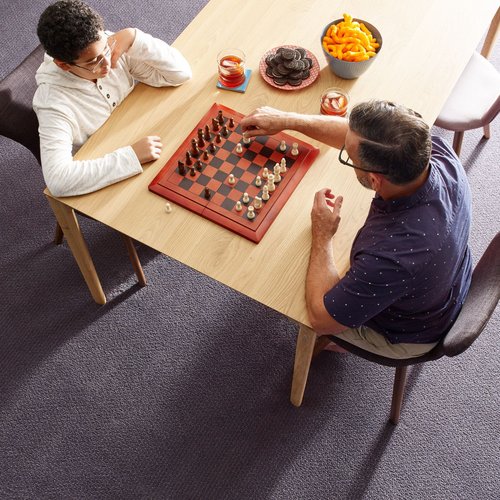 2 men playing chess in carpeted area - Whitley Flooring and Design in AR